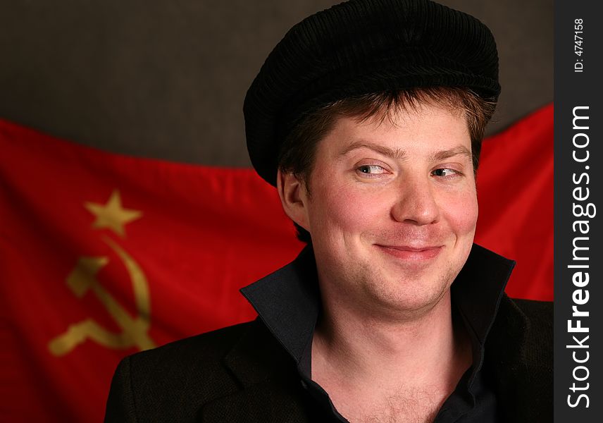 Portrait of the man in a cap on a background of a red flag. Portrait of the man in a cap on a background of a red flag