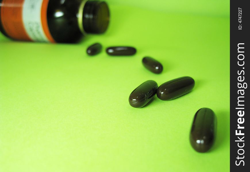 A bottle of pills on a green background