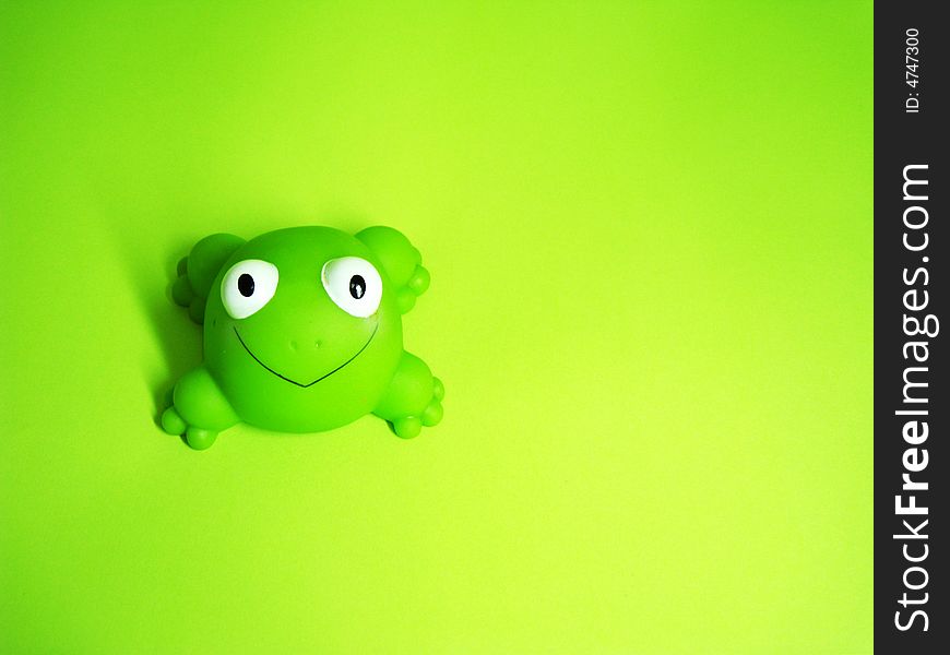 A frog toy on a green background