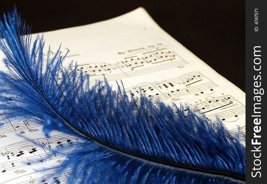 Piano sheets with blue feather