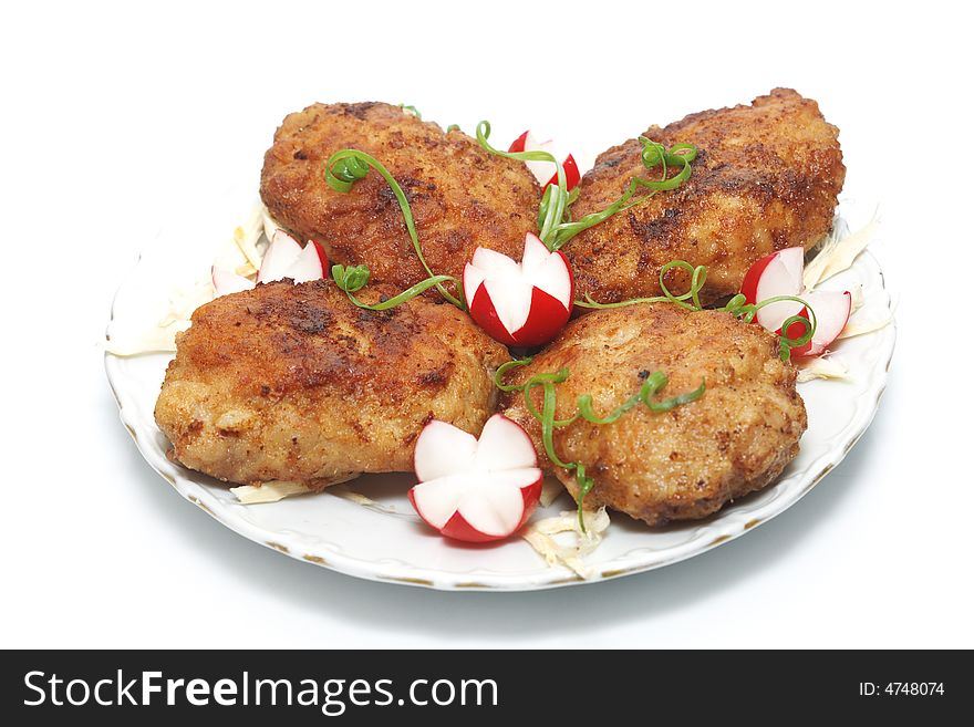 Meat rissoles with garden radish on a white round plate