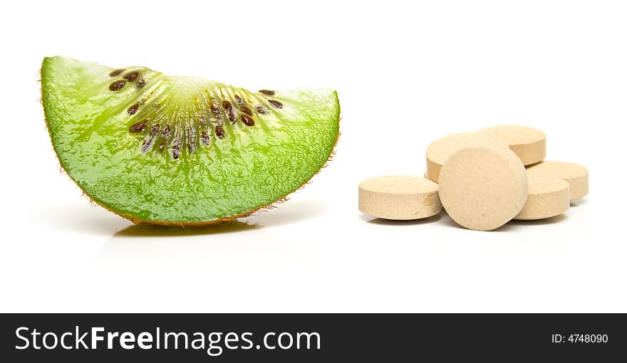 Segment kiwi and a handful of tablets on white. Isolation on white. Shallow DOF. Segment kiwi and a handful of tablets on white. Isolation on white. Shallow DOF.