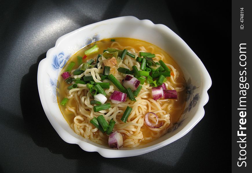 A bowl of instant noodles with spring onion dressing