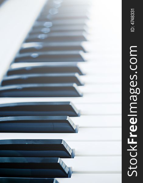 View of piano keys in sunlight with lens flare and low depth of field.