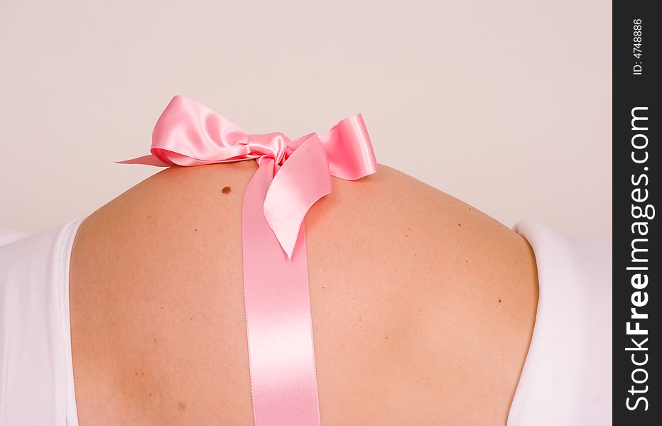 A pregnant belly with a pink gift wrap. A pregnant belly with a pink gift wrap