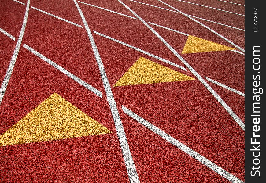 Shot of a black surfaced running track showing the lane markers of one through four and a grass covered infield. Shot of a black surfaced running track showing the lane markers of one through four and a grass covered infield.