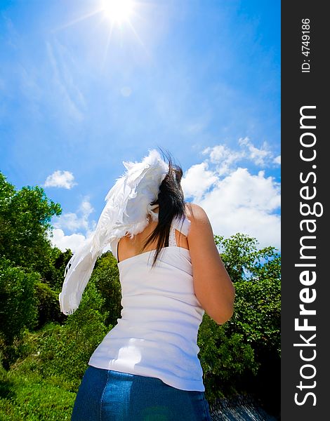 Woman with white angel wings looking up beautiful bright blue sky. Woman with white angel wings looking up beautiful bright blue sky