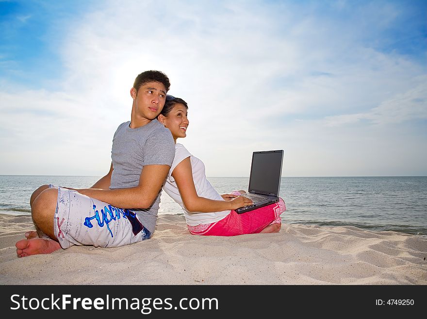 Couple Sitting On The Beach Relaxing