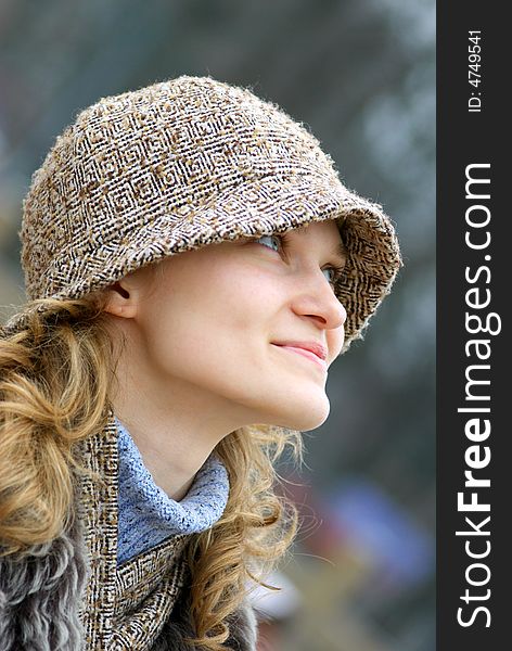 The beautiful girl in a cap looks upwards