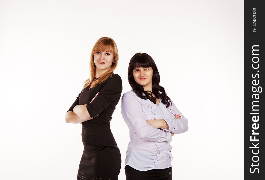 Two young beautiful business women standing smiling