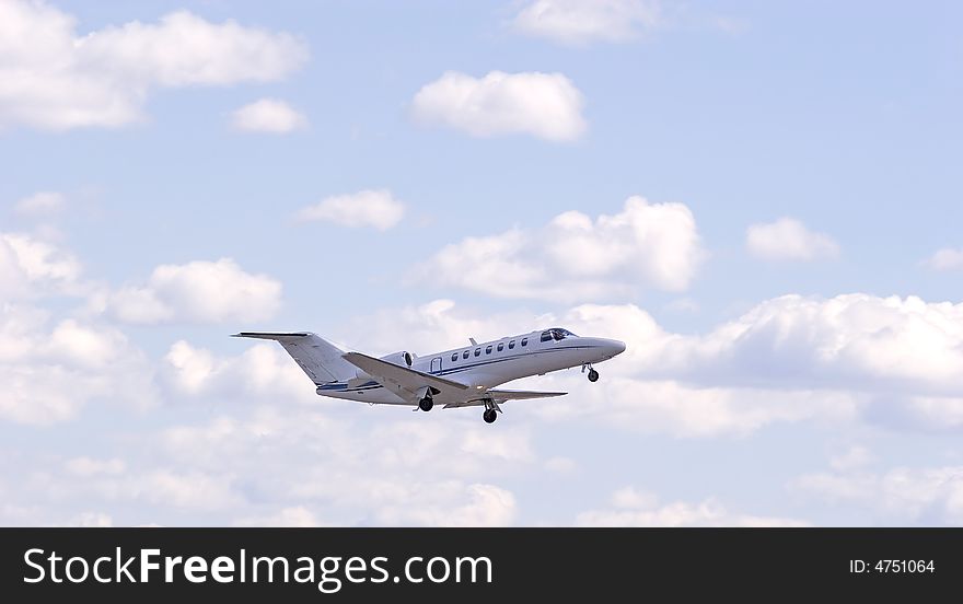 A small private jet ascending through the sky and clouds. A small private jet ascending through the sky and clouds