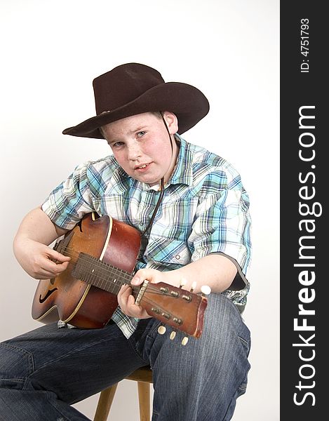 Young handsome cowboy playing the guitar. Young handsome cowboy playing the guitar