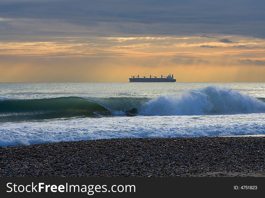 A ship in front of the beach under the clouds. A ship in front of the beach under the clouds