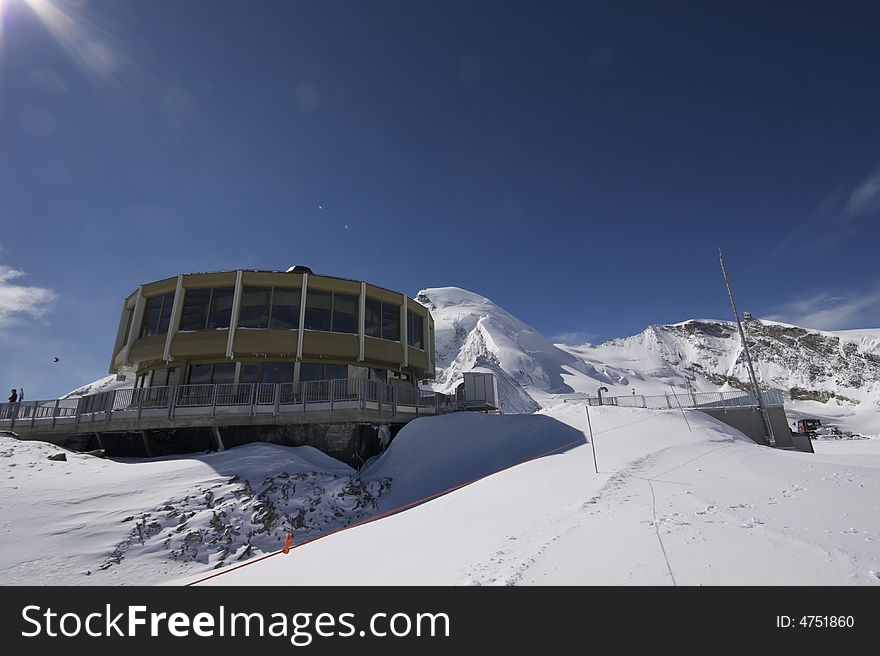 This photograph shows the top of a mountain in the resort of Saas-Fee in Switzerland. There are ski marks in the snow, and you can see down the valley over Saas-Fee and other mountain villages.

There is also a very interesting restaurant which inside has panoramic views over the valleys surrounding it. This photograph shows the top of a mountain in the resort of Saas-Fee in Switzerland. There are ski marks in the snow, and you can see down the valley over Saas-Fee and other mountain villages.

There is also a very interesting restaurant which inside has panoramic views over the valleys surrounding it.