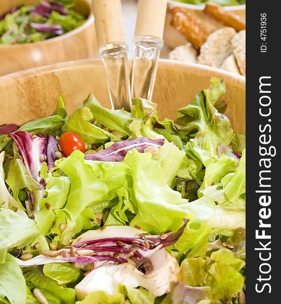 Green salad close up in a wooden salad bowl containing lettuce, arugula (roket), radicchio (chicory), cherry tomato, flax and sunflower seeds. Green salad close up in a wooden salad bowl containing lettuce, arugula (roket), radicchio (chicory), cherry tomato, flax and sunflower seeds.