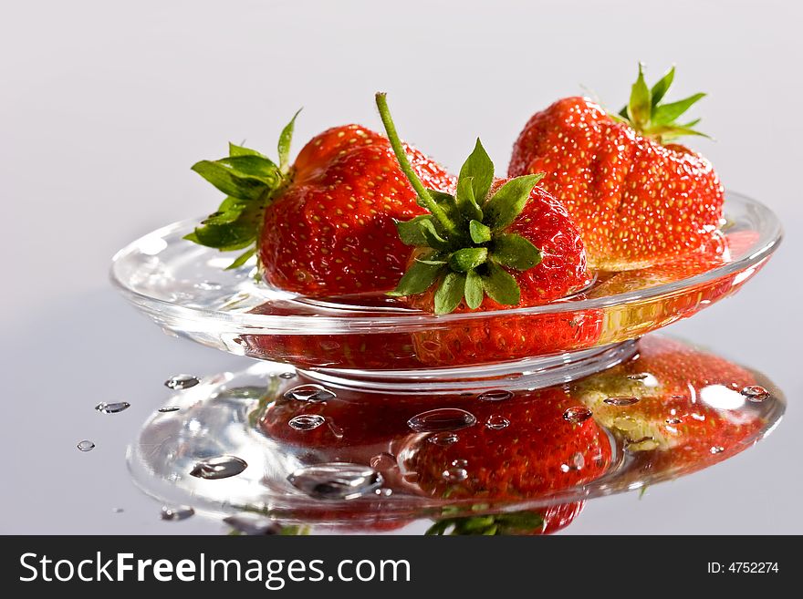 Fruit series: red ripe tasty strawberry on the glassy plate