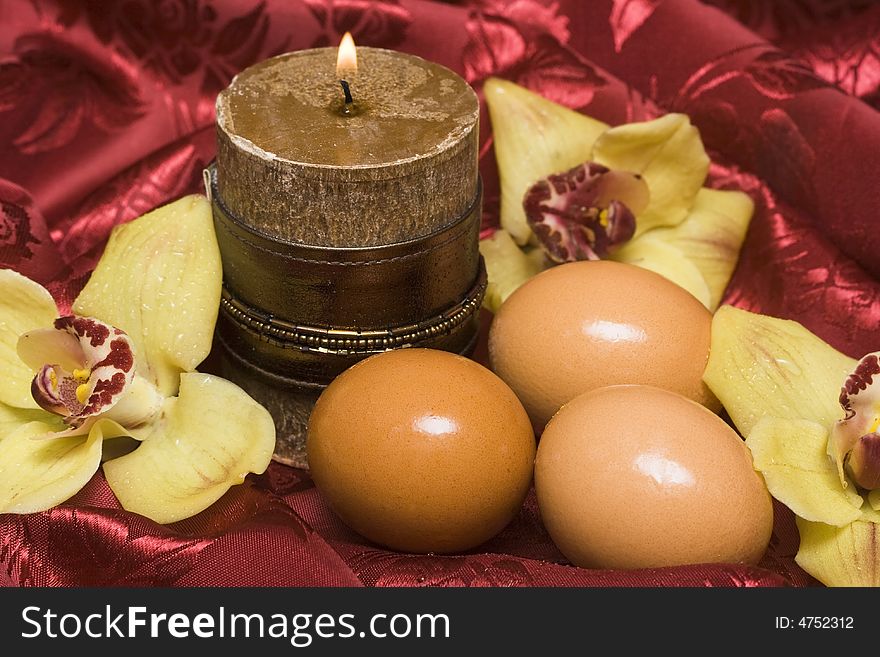 Easter eggs with yellow orchids and candle