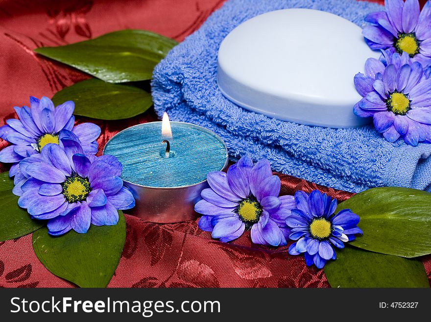 Spa essentials, soap, towel and candle with flowers