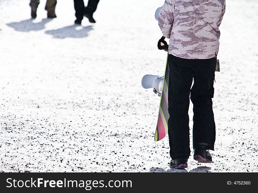A Young Female Holding Her Snowboard And Walking O