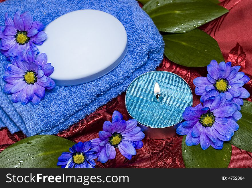 Spa essentials, soap, towel and candle with flowers