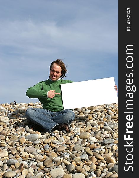 Young Man Holding White Card at the beach