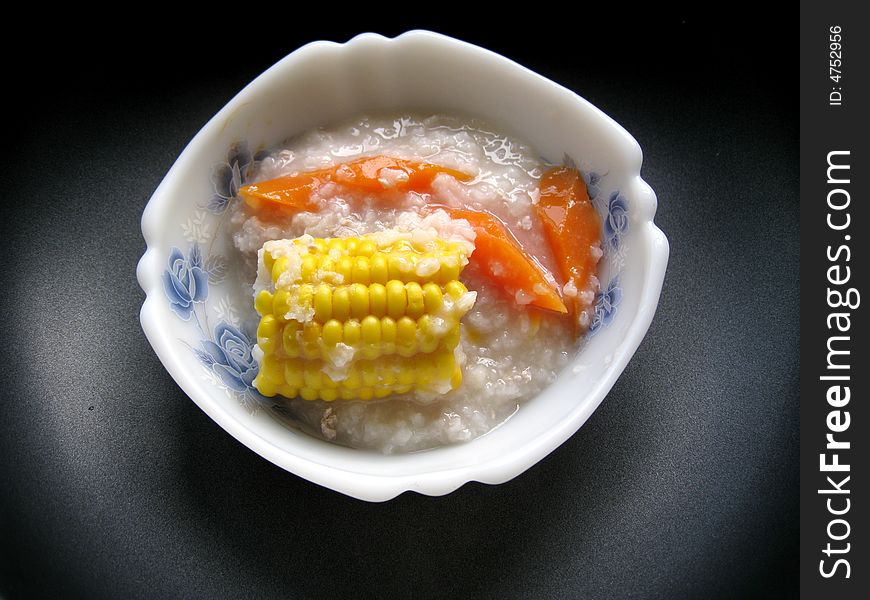 A bowl of porridge with corns and carrot