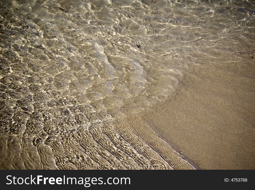 Close up of rippling water on sand. Close up of rippling water on sand