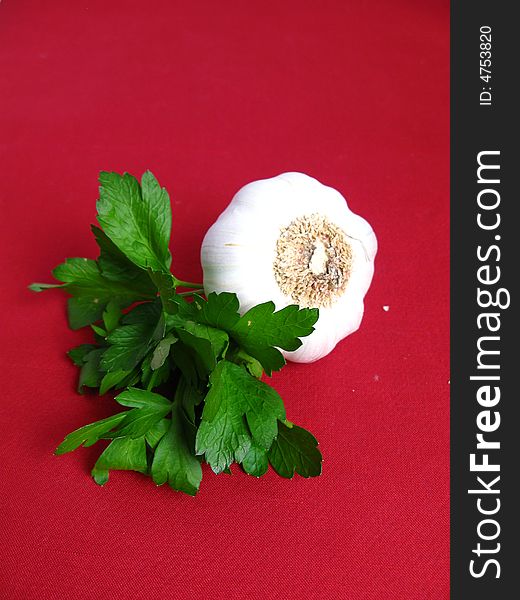 Bouquet of parsley tied with a white rope and Garlic, in red background. Bouquet of parsley tied with a white rope and Garlic, in red background.