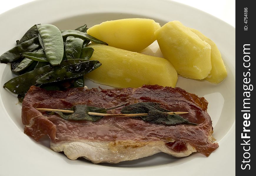 Saltimboca with potatoes and peas on a white plate. Saltimboca with potatoes and peas on a white plate
