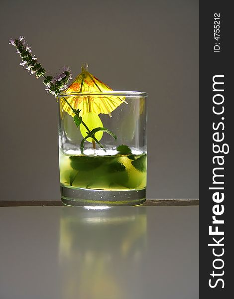 Mohito glass in studio with mint flower and umbrella decoration. Mohito glass in studio with mint flower and umbrella decoration