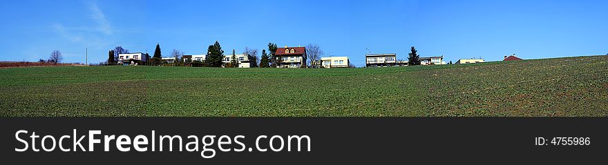 A panorama with square, blue sky and some houses in small village