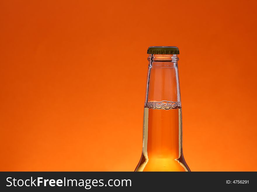 Close up of beer bottle over orange background