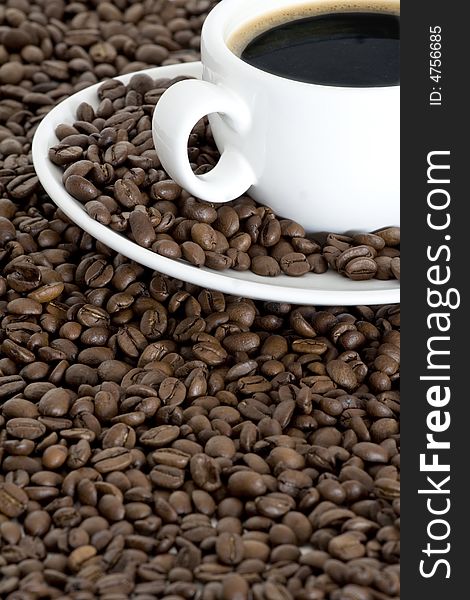 Cup of coffee view from above and coffee beans background. Cup of coffee view from above and coffee beans background
