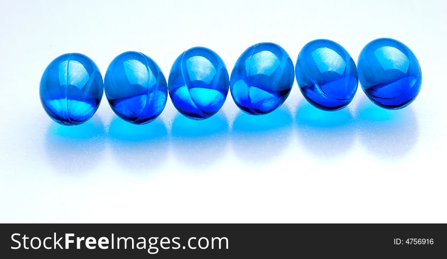 Blue pills in a row isolated on white background. Blue pills in a row isolated on white background