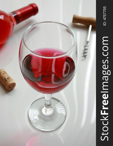 Red wine glass with corkscrew and cork