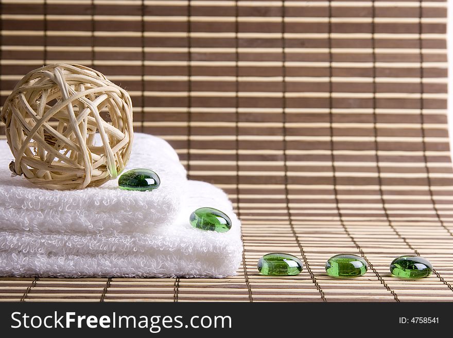 Two white towels and five glass green stones. Two white towels and five glass green stones