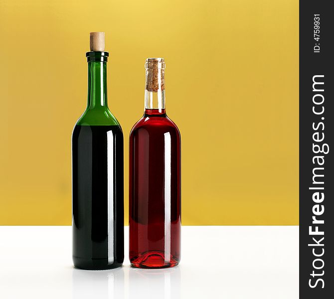 Two bottles of wine on yellow background