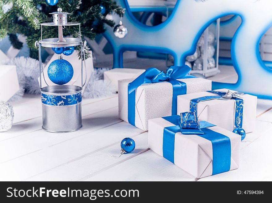White Christmas gifts with blue ribbon on white wooden floor. White Christmas gifts with blue ribbon on white wooden floor