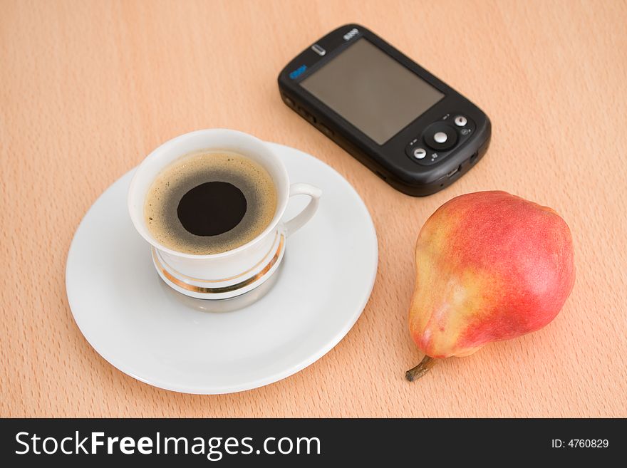 Businessman's coffee break with cup of coffee, pear and PDA for keeping online