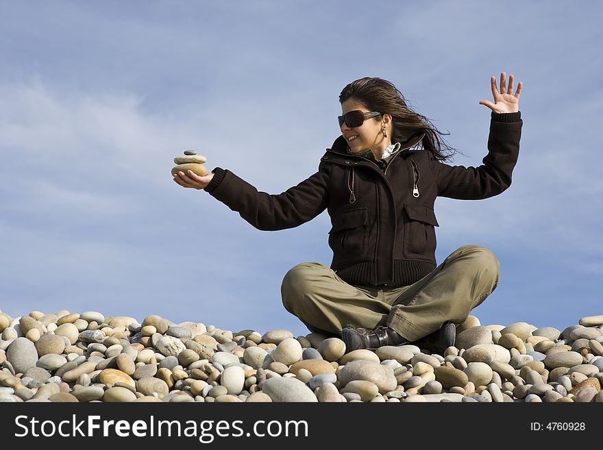 Young casual woman holding pile of round stones in the hand
