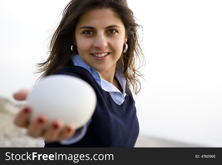 Young casual happy woman holding small white rock. Young casual happy woman holding small white rock