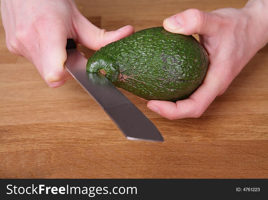 Avocado while being cut with a knife