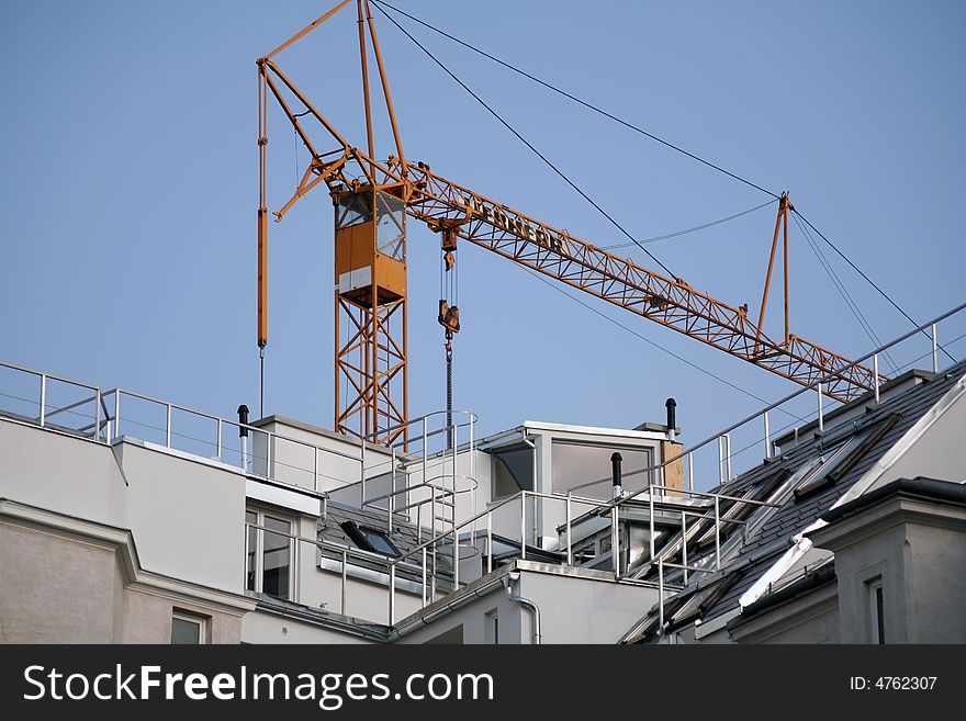 House renovations with a crane, sky background.