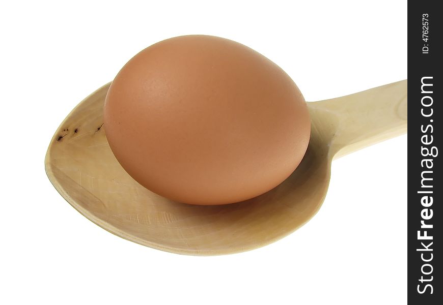 Close up to an egg on wooden spoon over white