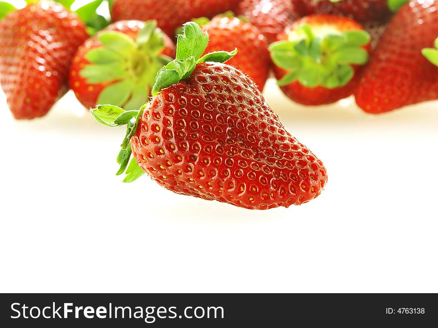 Close up of fresh strawberry with a lot of them as a background