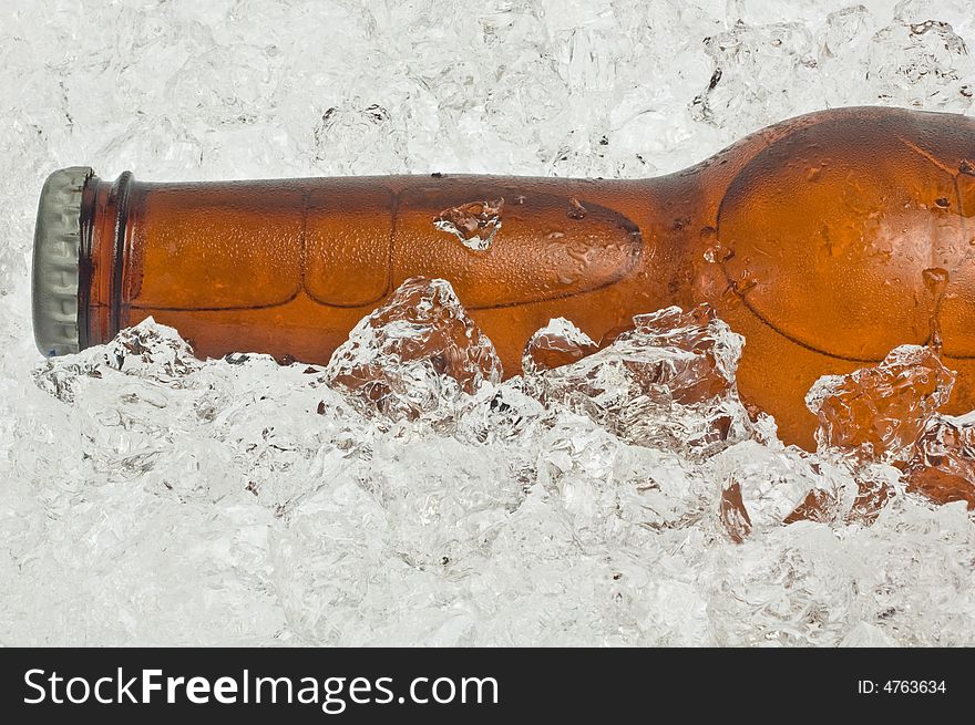 Close-up of the neck of an ice cold beer, resting in crushed ice. Close-up of the neck of an ice cold beer, resting in crushed ice.