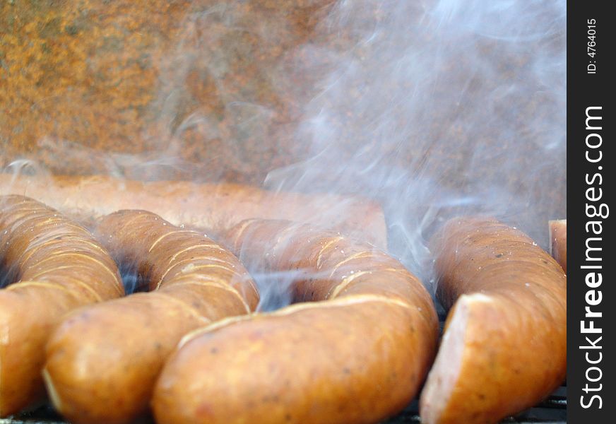 A polish sausages grilled on a grill. A polish sausages grilled on a grill