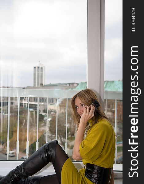 Woman talks on the phone (focus on the cup of coffee)