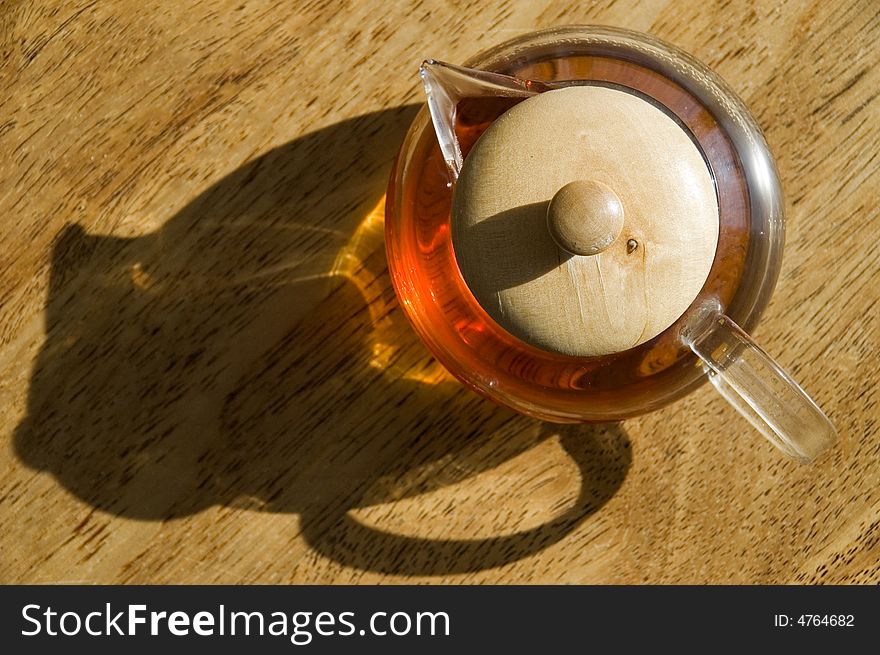 Transparent cup of tea on a wooden floor.