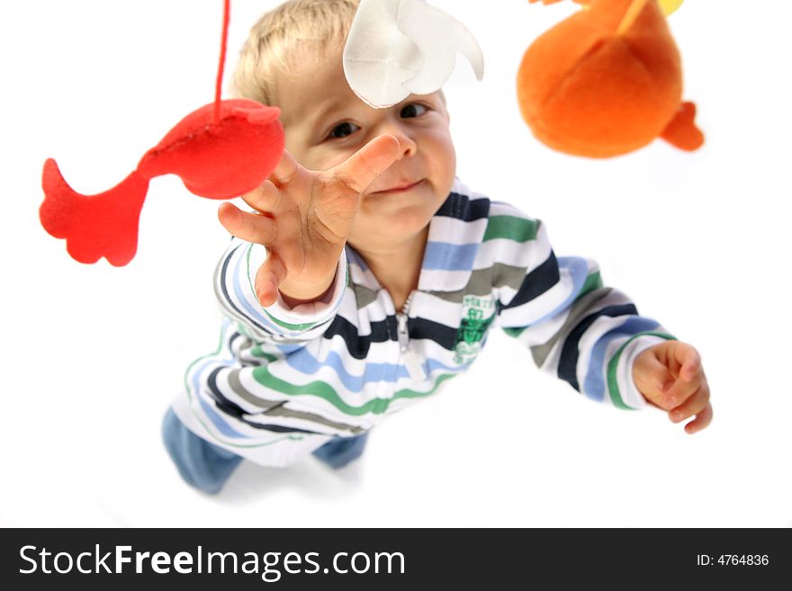 Young boy reaching for his hanging toys. Young boy reaching for his hanging toys